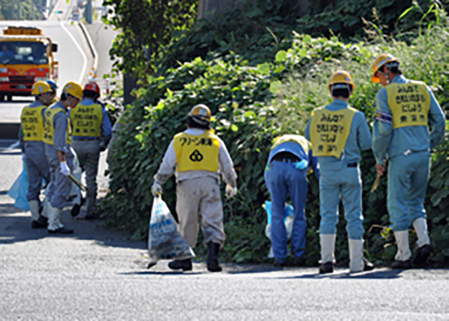 荒尾インターチェンジ付近の歩道を清掃する名協会の皆さん