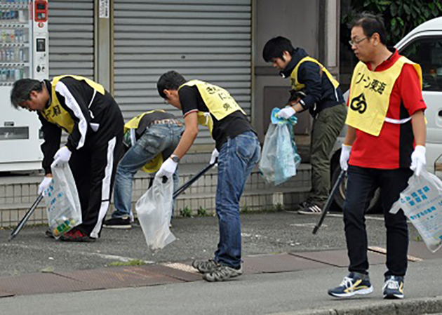 東海市東海町内の歩道や路肩を清掃する当所社員（左）・名協会の有志