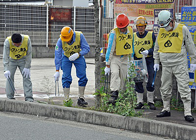東海市東海町内の歩道や路肩を清掃する当所社員（左）・名協会の有志