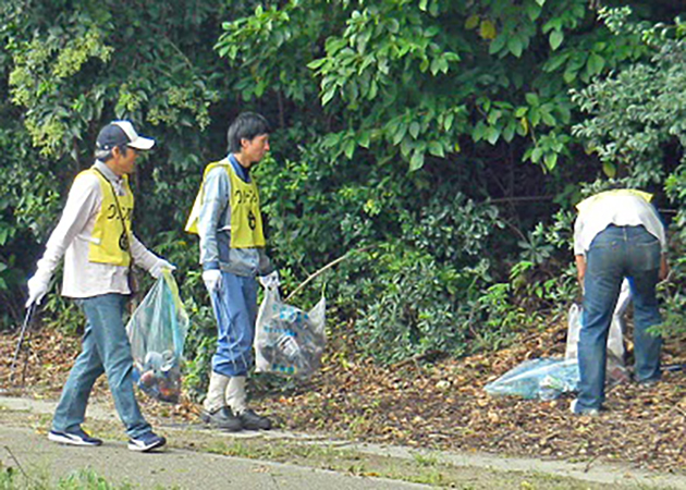 東海市東海町内の歩道や路肩を清掃する当所協力会の有志（左）と当所社員有志
