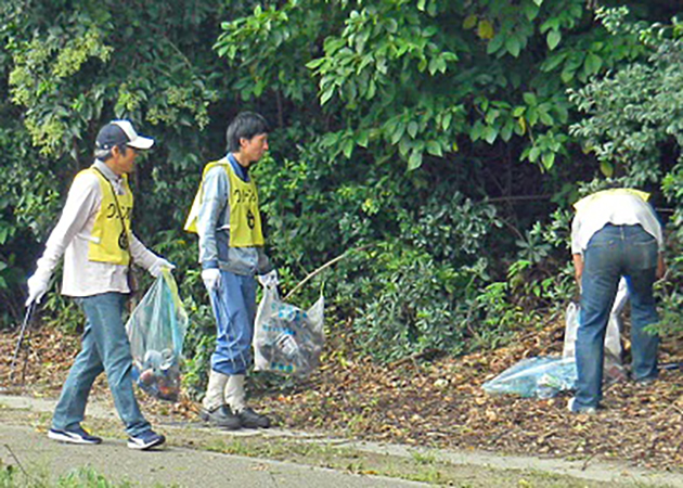 東海市東海町内の歩道や路肩を清掃する当所協力会の有志（左）と当所社員有志